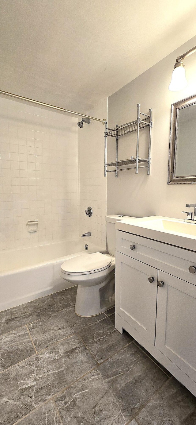 full bathroom featuring toilet, vanity, and tiled shower / bath