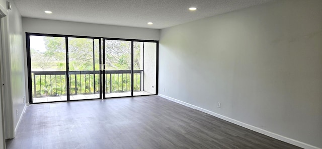 spare room with a textured ceiling and dark wood-type flooring