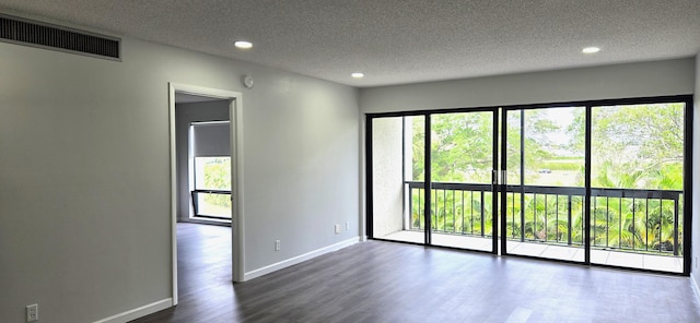 empty room with a textured ceiling and dark wood-type flooring