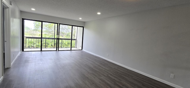 spare room featuring dark hardwood / wood-style flooring and a textured ceiling