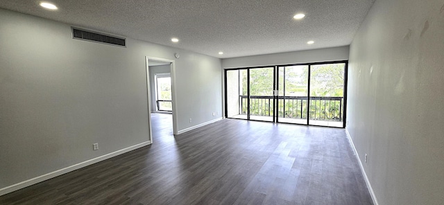 unfurnished room featuring a textured ceiling and dark hardwood / wood-style floors