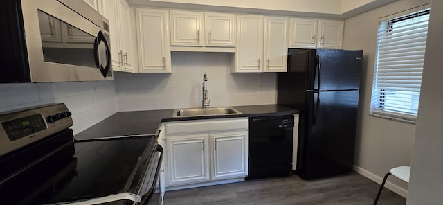 kitchen with black appliances, a healthy amount of sunlight, dark wood-type flooring, white cabinets, and sink