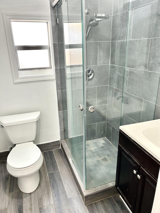 bathroom featuring vanity, toilet, and an enclosed shower