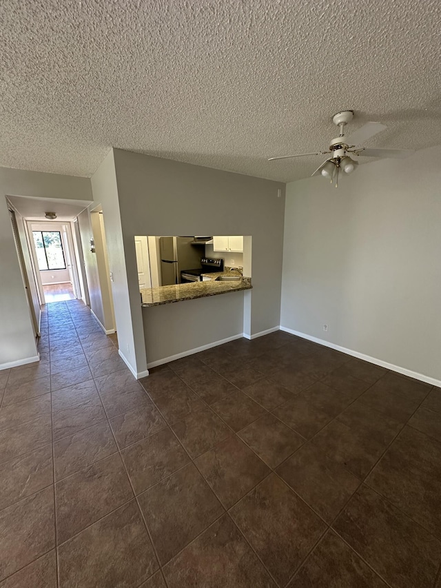 unfurnished living room with a textured ceiling and ceiling fan