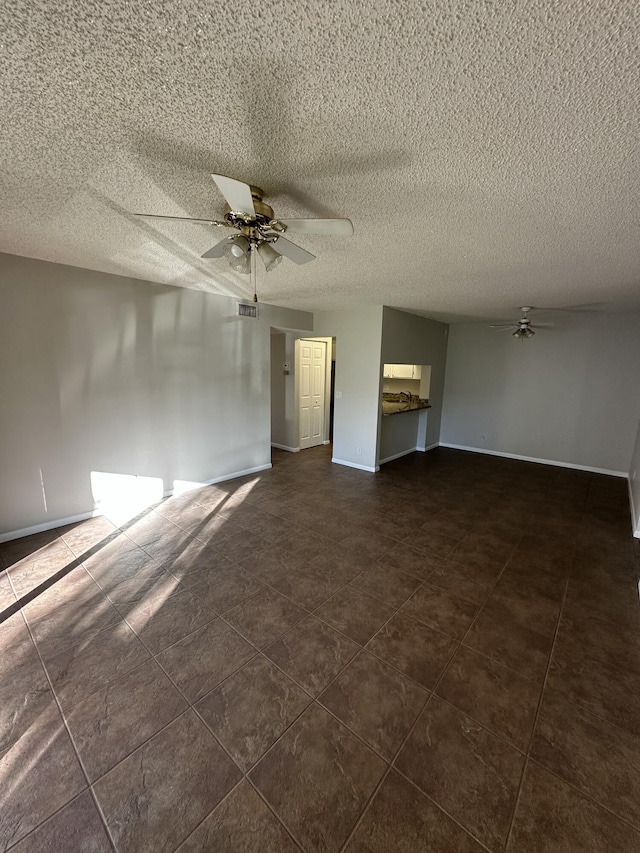 unfurnished living room featuring ceiling fan and a textured ceiling