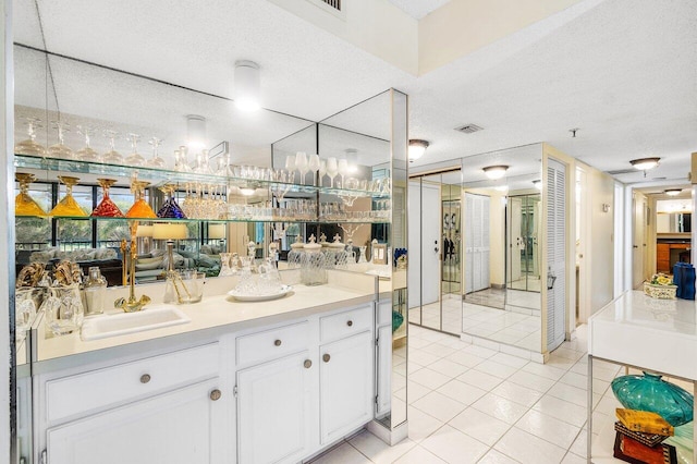 bathroom featuring tile patterned flooring, vanity, and a textured ceiling