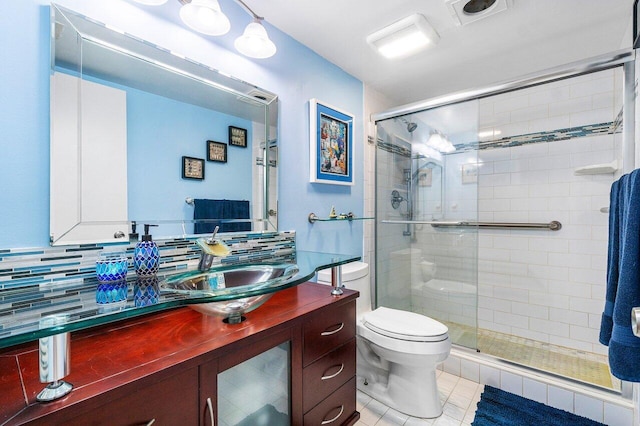 bathroom featuring vanity, decorative backsplash, a shower with shower door, tile patterned floors, and toilet