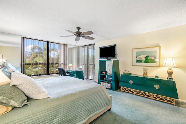 carpeted bedroom featuring expansive windows, ceiling fan, and a textured ceiling