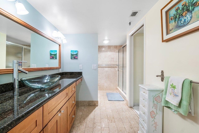 bathroom featuring vanity and a shower with door