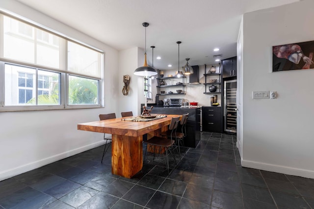 kitchen featuring decorative light fixtures, wall chimney exhaust hood, and a breakfast bar area