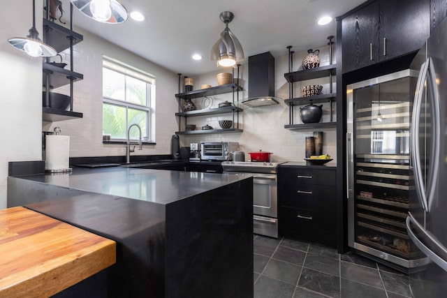 kitchen with tasteful backsplash, pendant lighting, exhaust hood, and appliances with stainless steel finishes