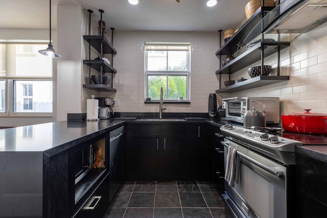 kitchen featuring backsplash, kitchen peninsula, sink, and appliances with stainless steel finishes