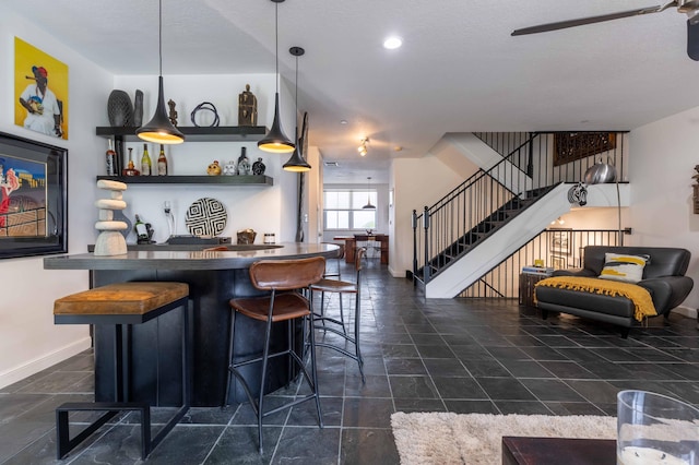 kitchen with pendant lighting, a kitchen bar, and a textured ceiling