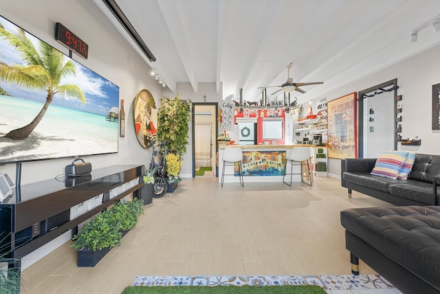 living room with ceiling fan, light wood-type flooring, and beamed ceiling