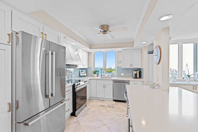 kitchen featuring appliances with stainless steel finishes, white cabinetry, decorative backsplash, ceiling fan, and light tile patterned floors