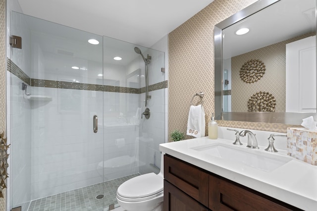 bathroom with toilet, vanity, and an enclosed shower