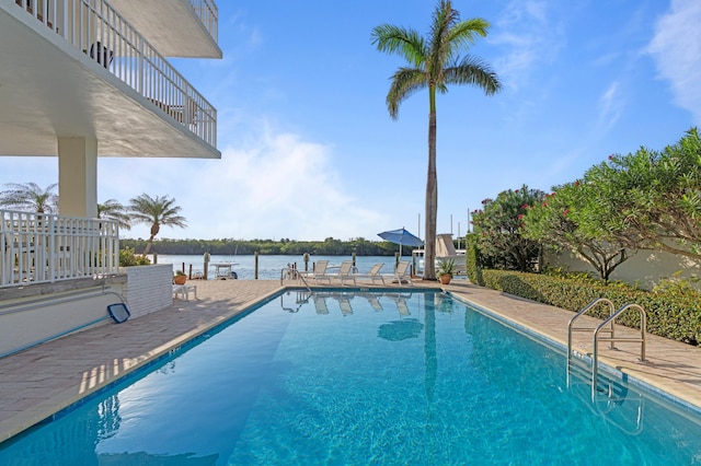 view of swimming pool with a water view and a patio