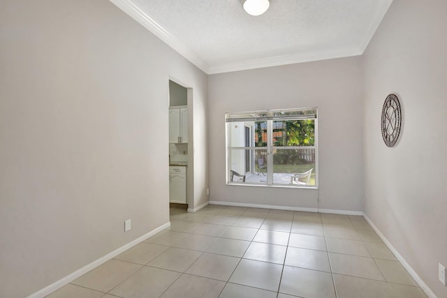 tiled spare room with a textured ceiling and crown molding