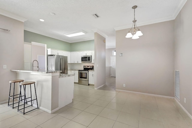 kitchen with hanging light fixtures, an inviting chandelier, crown molding, white cabinets, and appliances with stainless steel finishes