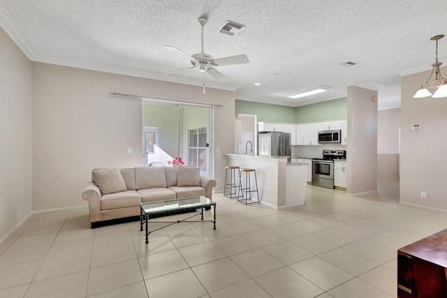 living room featuring light tile patterned floors, ceiling fan with notable chandelier, and ornamental molding