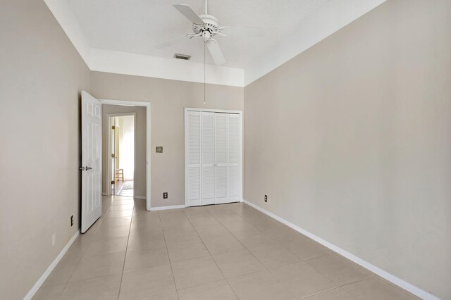 unfurnished bedroom featuring ceiling fan, a closet, and light tile patterned floors