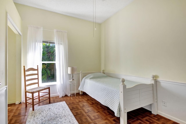 bedroom with dark parquet flooring and a textured ceiling