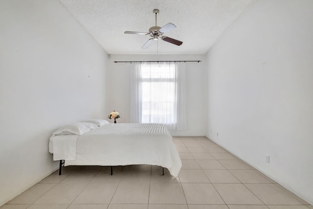 tiled bedroom featuring ceiling fan and a textured ceiling