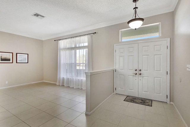 foyer entrance with crown molding, light tile patterned floors, and a healthy amount of sunlight