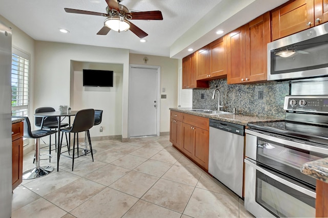 kitchen with ceiling fan, sink, light tile patterned floors, and stainless steel appliances