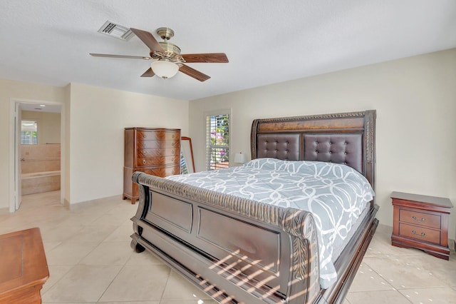 bedroom featuring light tile patterned floors, ensuite bathroom, and ceiling fan