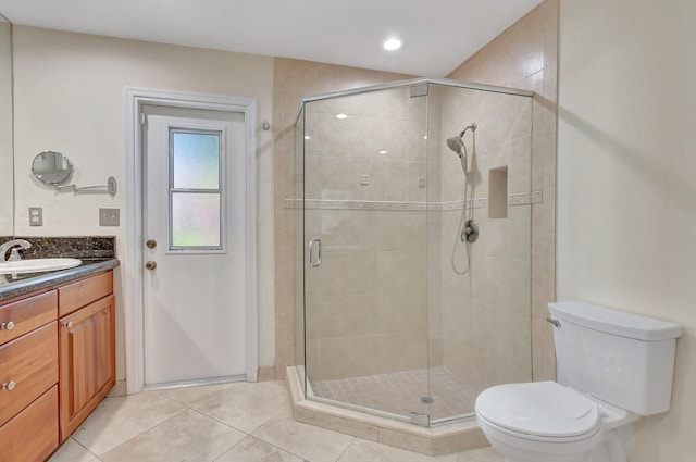 bathroom with tile patterned floors, vanity, toilet, and walk in shower