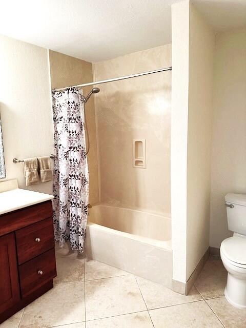 full bathroom featuring toilet, vanity, shower / tub combo with curtain, and tile patterned flooring