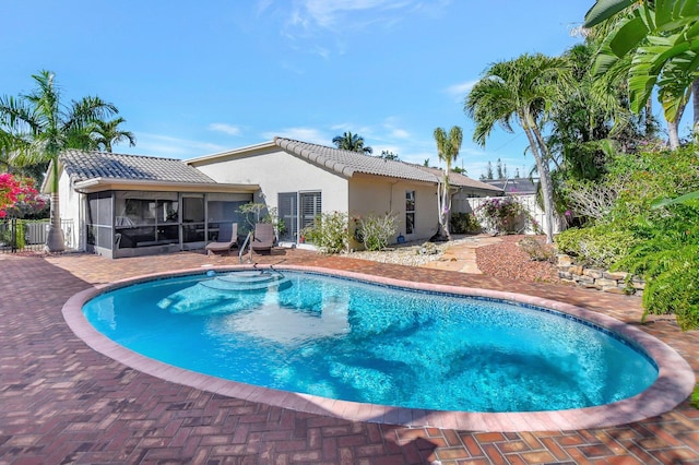 view of swimming pool with a sunroom and a patio area