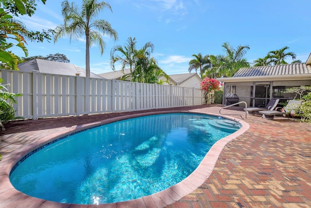 view of pool with a sunroom and a patio