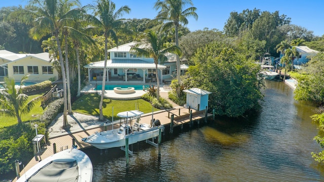 view of dock featuring a water view, a fenced backyard, a patio area, boat lift, and an outdoor pool