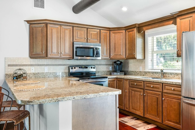 2897 SE Saint Lucie Blvd, Stuart, FL 34997 - kitchen featuring visible vents, a peninsula, a sink, vaulted ceiling, and stainless steel appliances