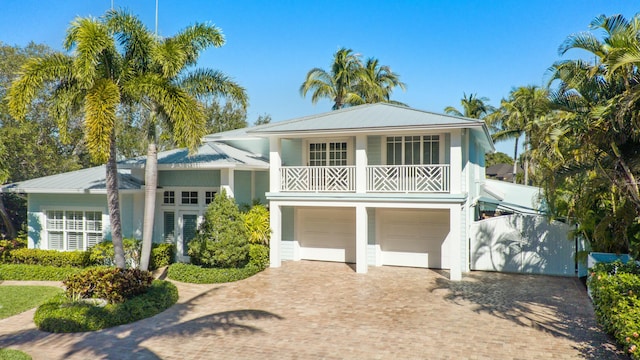 2897 SE Saint Lucie Blvd, Stuart, FL 34997 - view of front facade with a garage, metal roof, decorative driveway, and a balcony