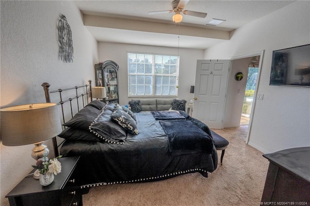 bedroom featuring ceiling fan, light carpet, and a textured ceiling