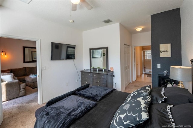 bedroom featuring light carpet, ceiling fan, and a closet