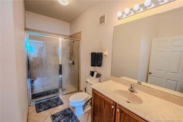 bathroom featuring vanity, an enclosed shower, tile patterned floors, and toilet