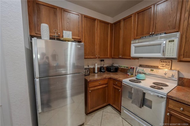 kitchen with light tile patterned floors and white appliances