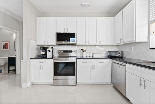 kitchen with stainless steel appliances, white cabinetry, and light tile patterned floors