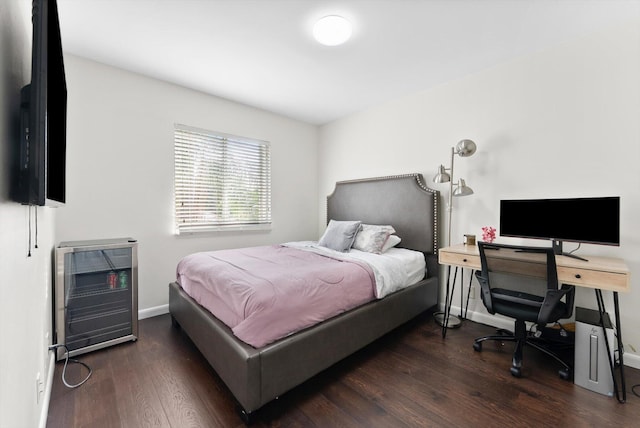 bedroom with heating unit and dark hardwood / wood-style floors