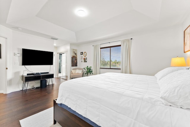 bedroom featuring dark wood-type flooring and a raised ceiling