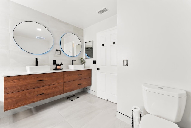 bathroom featuring toilet, tile patterned flooring, and vanity