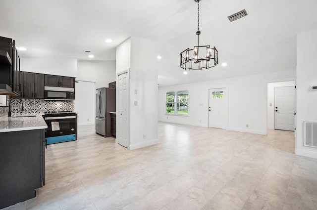 kitchen featuring decorative light fixtures, decorative backsplash, an inviting chandelier, range with electric cooktop, and stainless steel fridge