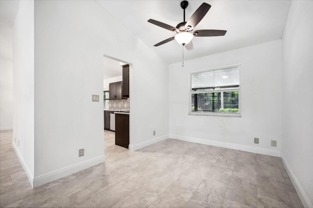 empty room featuring ceiling fan and vaulted ceiling