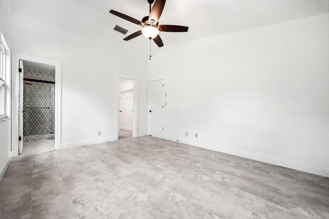 unfurnished bedroom with ceiling fan, lofted ceiling, a closet, and a walk in closet