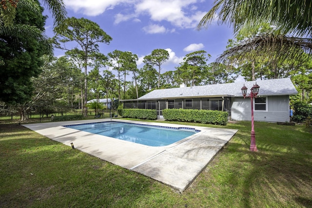 view of pool with a sunroom and a lawn