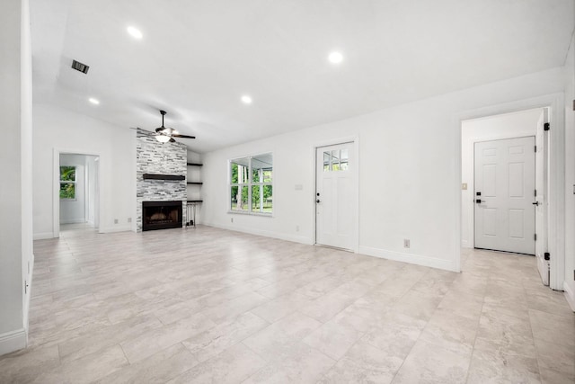 unfurnished living room featuring ceiling fan, a large fireplace, and lofted ceiling